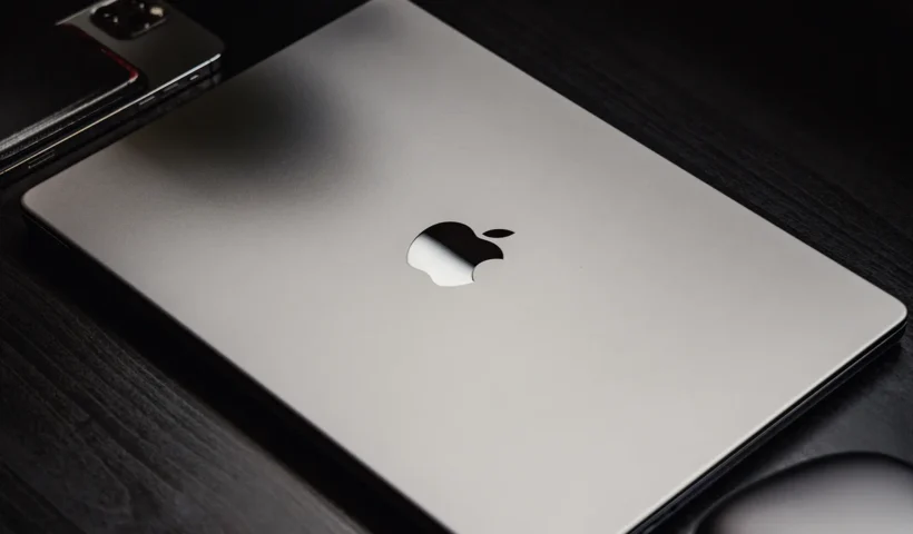 Apple event stage graphic announcing March 4 keynote with MacBook silhouette and Apple logo illuminated in a modern presentation setting.