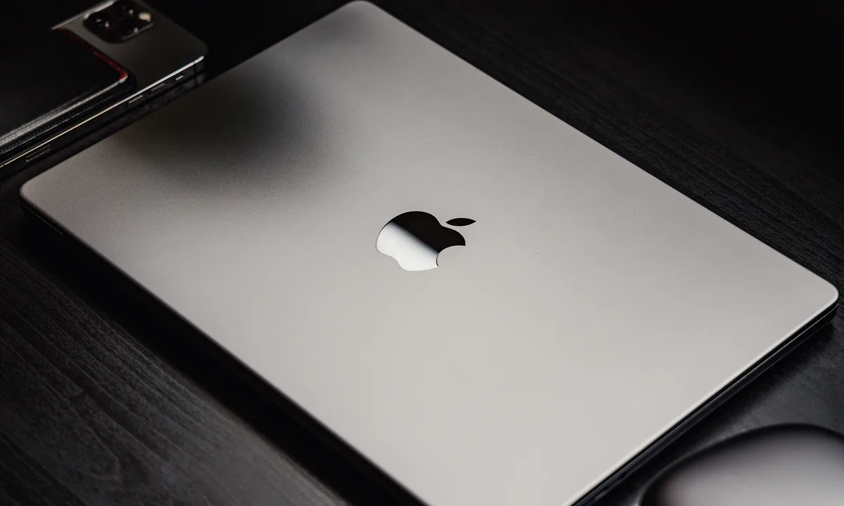 Apple event stage graphic announcing March 4 keynote with MacBook silhouette and Apple logo illuminated in a modern presentation setting.